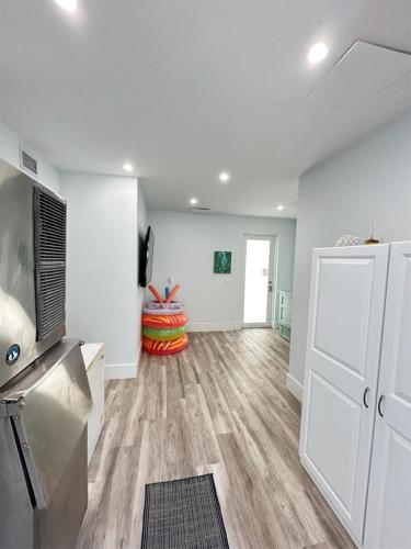 an empty living room with white walls and wood floors at Casa Playa- Luxury Pool Home, 36' Dock in Marathon
