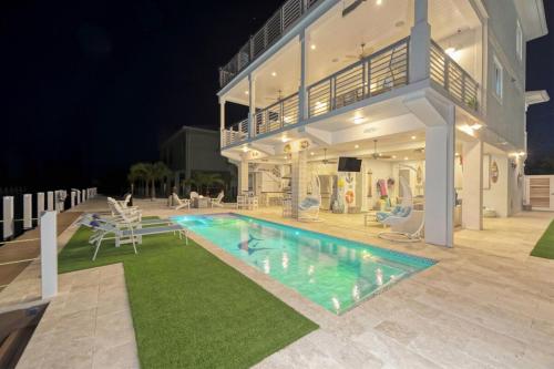 a swimming pool in front of a house at night at Casa Playa- Luxury Pool Home, 36' Dock in Marathon