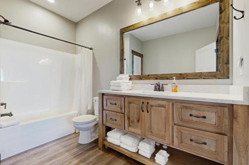 a bathroom with a sink and a toilet and a mirror at The Big Blue in Garden City