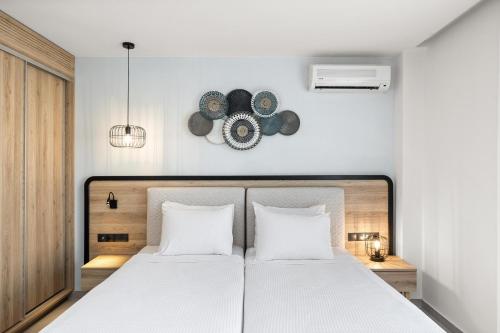 a bedroom with a large white bed with two pillows at White Olive Marine Aquapark in Tigaki