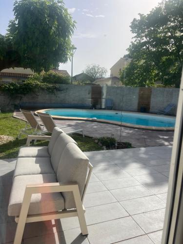 - un canapé et des chaises à côté de la piscine dans l'établissement Superbe Villa climatisée avec piscine, à Lavérune