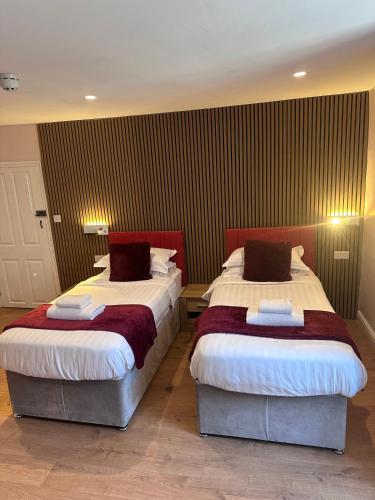 a bedroom with two beds with red and white sheets at Laburnum Guest House at Bistro En Glaze in Wylam