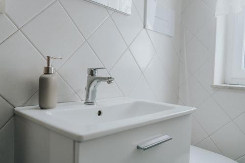 a bathroom sink with a soap dispenser on it at Shalom Portici in Portici