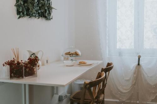 a white table with chairs and a table with food on it at Shalom Portici in Portici