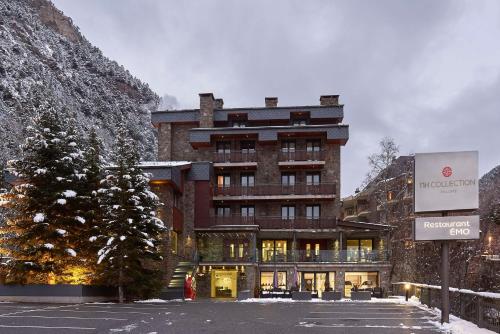 a large brick building with a tree in front of it at NH Collection Andorra Palomé in La Massana