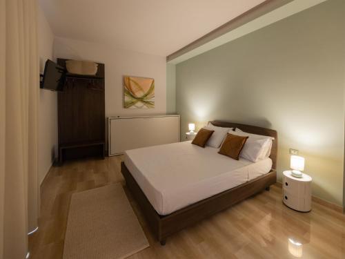 a bedroom with a large bed with two lamps on it at Domus Eterea in Marsala
