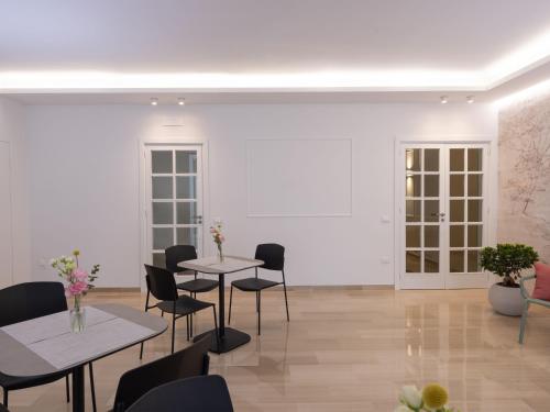 a white room with two tables and chairs at Domus Eterea in Marsala