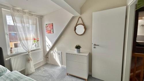 a bedroom with a staircase and a dresser and a mirror at Idyllisches Dorfhaus vor Usedom in Gützkow