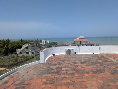 una pasarela con suelo de ladrillo y una pared en ANV Beach house, en Kovakulam