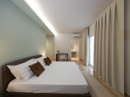a bedroom with a bed with white sheets and a window at Domus Eterea in Marsala