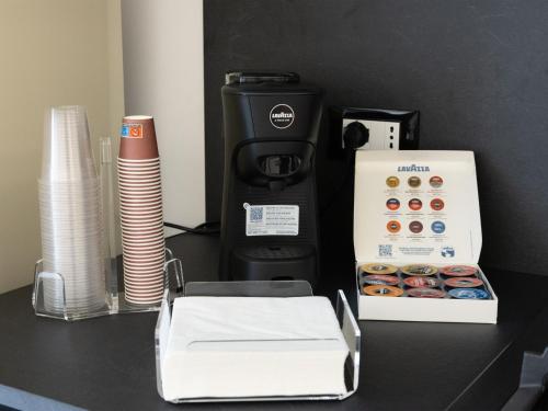 a counter with a coffee maker and a box of donuts at Domus Eterea in Marsala