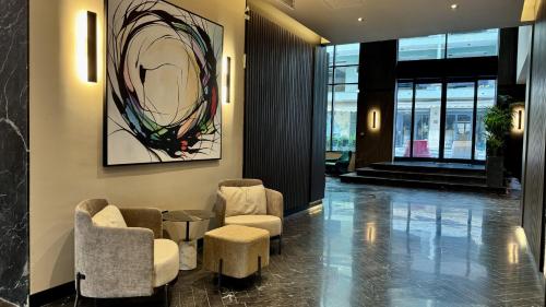 a lobby with chairs and a painting on the wall at ASTE hotel in St Julian's