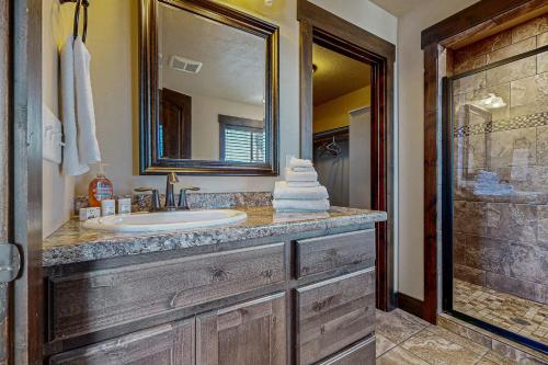 a bathroom with a sink and a mirror and a shower at Heider Cabin in Garden City