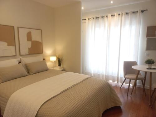 a bedroom with a bed and a table and a window at Cozy Private Room in Nazaré - Independent Entrance - No Sharing Areas in Nazaré