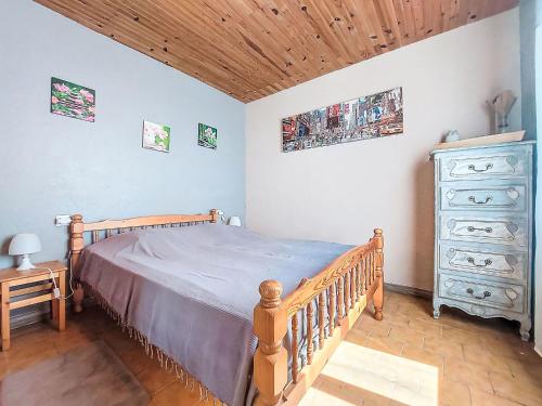 - une chambre avec un lit en bois et une commode dans l'établissement Holiday Home L'Estuaire by Interhome, à Bégadan