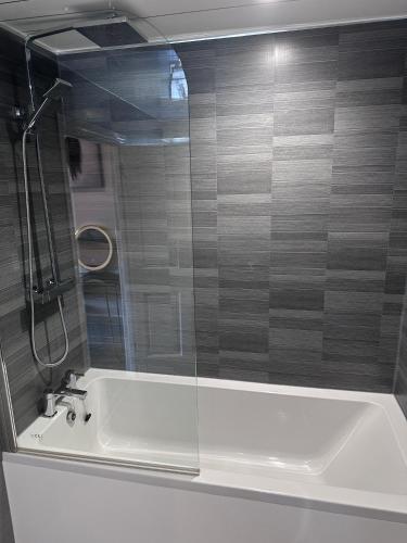 a bathroom with a bath tub with a glass shower at Laburnum Guest House at Bistro En Glaze in Wylam