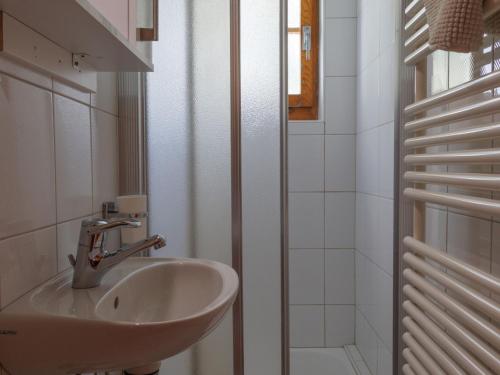 a white bathroom with a sink and a shower at Chalet Les Clarines by Interhome in Grimentz
