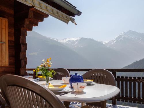 a table on a balcony with a view of mountains at Chalet Les Clarines by Interhome in Grimentz