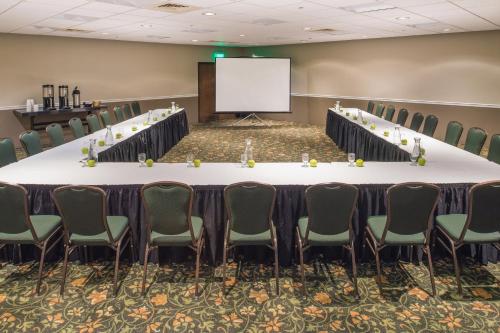 a conference room with a long table and chairs and a screen at Red Lion Hotel Kennewick Columbia Center in Kennewick