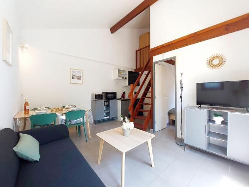 a living room with a couch and a table at Holiday Home Les Charmilles-6 by Interhome in La Palmyre