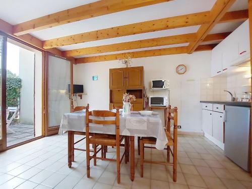 una cocina con una mesa y sillas y una cocina con una mesa y una mesa en Holiday Home Jardins de l'Océan-1 by Interhome, en Saint-Georges-de-Didonne