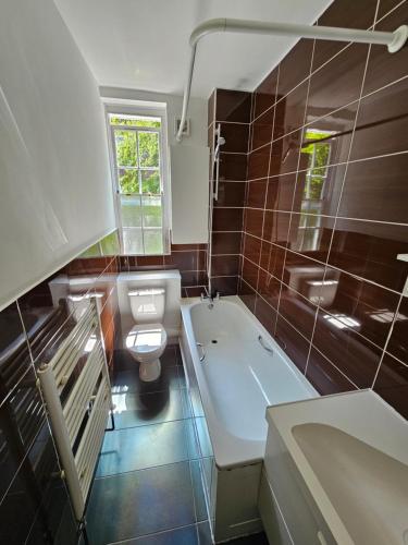 a bathroom with a tub and a toilet and a sink at Flat in Hammersmith - Close to tube station in London