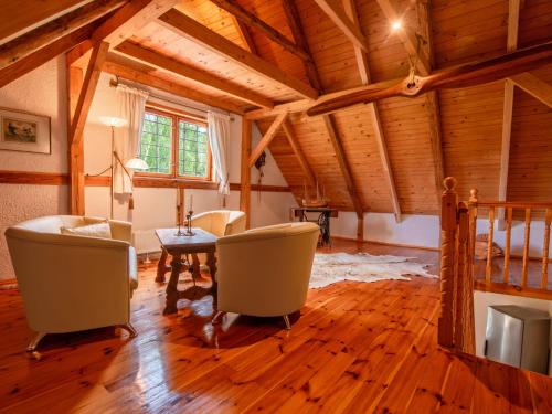 a living room with wooden ceilings and a table and chairs at Holiday Home Sianowska Huta by Interhome in Sianowska Huta
