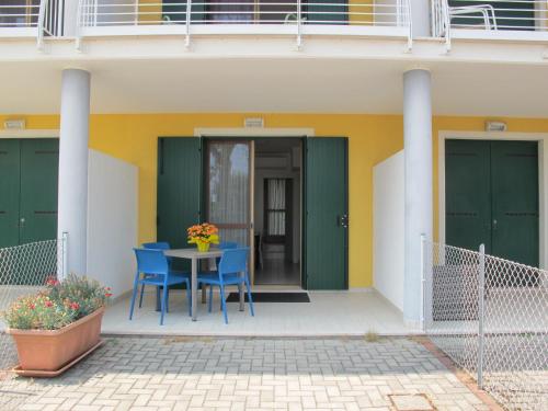 a patio with blue chairs and a table in front of a building at Holiday Home Malva by Interhome in Bagni