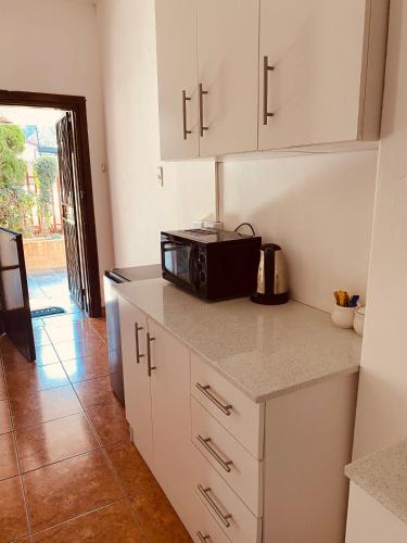 a kitchen with a microwave on top of a counter at khayelihle guest house in Benoni