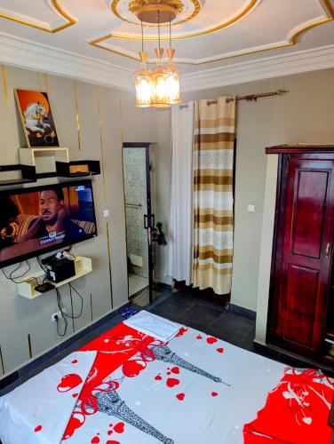 a living room with a bed with red flowers on it at Rams Eng Home in Douala