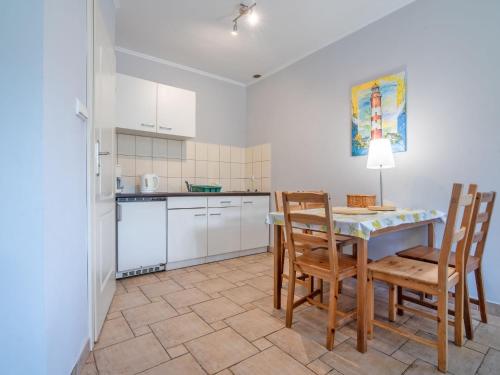 a kitchen with a table and chairs in a room at Holiday Home Domek Joanna-3 by Interhome in Łeba