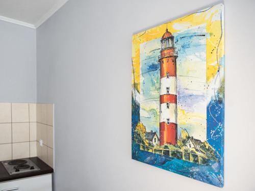 a painting of a lighthouse on a wall in a kitchen at Holiday Home Domek Joanna-3 by Interhome in Łeba