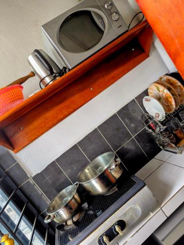 two pots on top of a stove in a kitchen at Rams Eng Home in Douala