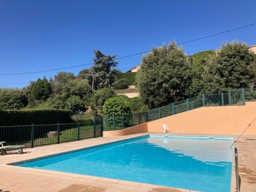 une piscine entourée d'une clôture dans l'établissement Villa climatisée calme avec piscine partagée Saint AYGULF/FREJUS, à Saint-Aygulf