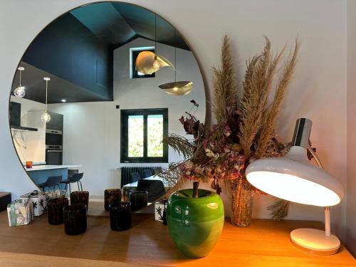 un salon avec un vase vert et un miroir dans l'établissement Maison avec piscine le puy en velay, à Vals-près-le-Puy