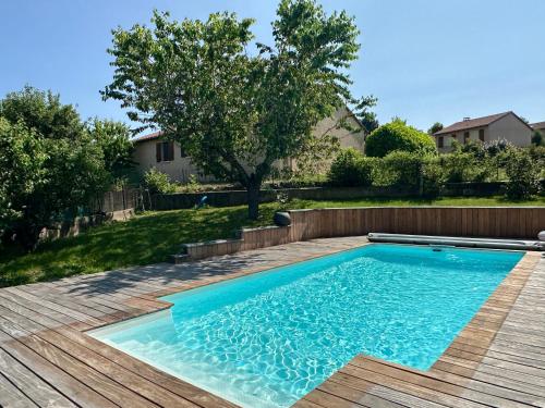 - une piscine dans une cour avec une terrasse en bois dans l'établissement Maison avec piscine le puy en velay, à Vals-près-le-Puy