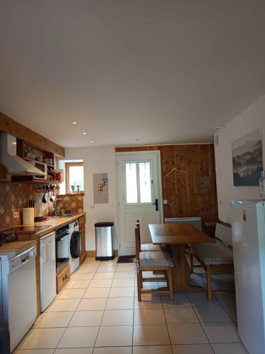 Il comprend une cuisine équipée d'une table et d'un réfrigérateur. dans l'établissement Appartement au calme, à Saint-Gervais-les-Bains