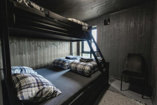 two bunk beds in a room with a window at Modern And Inviting Cabin In Valdres in Aurdal