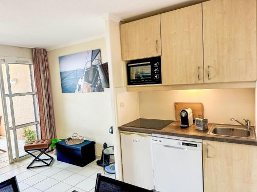 une cuisine avec un évier et un micro-ondes dans l'établissement Apartment L'Esquinade - G4 126 by Interhome, à Agay