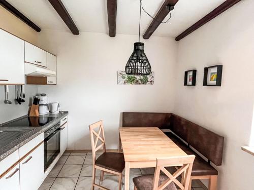 a small kitchen with a wooden table and chairs at Apartment Am Hohen Bogen-11 by Interhome in Arrach