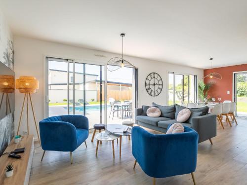 un salon avec des chaises bleues et un canapé dans l'établissement Holiday Home Villa Ty Coz by Interhome, à Cléder