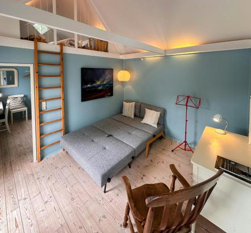 a bedroom with a bed and a ladder and a desk at Architect-Designed Summer House Near Hald Strand in Liseleje