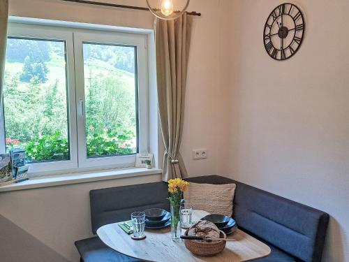 a dining room table and a window with a clock at Apartment Apartement Haus Dankl by Interhome in Fusch an der Glocknerstraße
