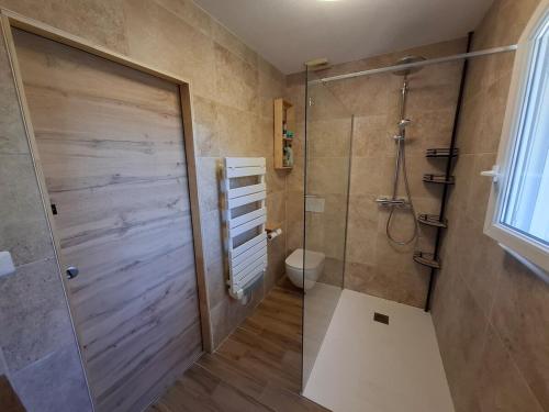 La salle de bains est pourvue d'une douche, de toilettes et d'une porte en verre. dans l'établissement Maison Harmonia! Private Pool, BBQ, AC and Playground, à Besse-sur-Issole