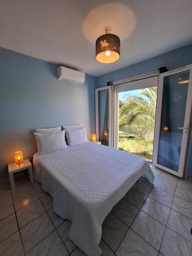 une chambre avec un lit blanc et une grande fenêtre dans l'établissement Maison Harmonia! Private Pool, BBQ, AC and Playground, à Besse-sur-Issole