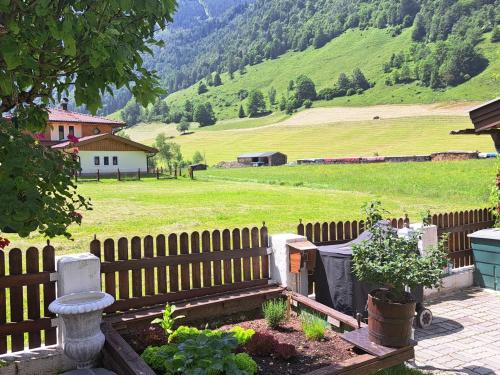 a fence in a yard with a field and a mountain at Apartment Apartement Haus Dankl by Interhome in Fusch an der Glocknerstraße