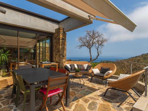 d'une terrasse avec une table et des chaises noires. dans l'établissement Holiday Home Village des Fourches by Interhome, à Bormes-les-Mimosas