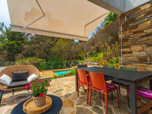 d'une terrasse avec une table et des chaises noires. dans l'établissement Holiday Home Village des Fourches by Interhome, à Bormes-les-Mimosas