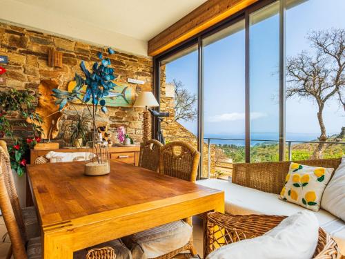 - un salon avec une table en bois et de grandes fenêtres dans l'établissement Holiday Home Village des Fourches by Interhome, à Bormes-les-Mimosas