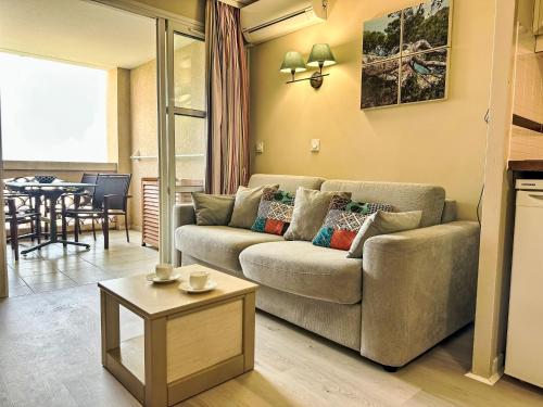 un salon avec un canapé et une table dans l'établissement Apartment Village Cap Estérel - L'Esquinade-108 by Interhome, à Drammont